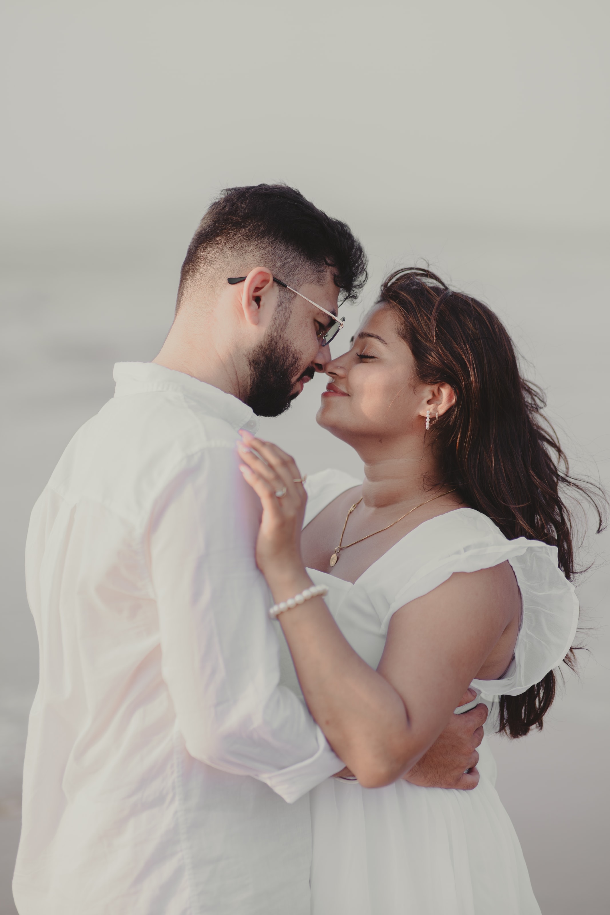 A couple in white on the beach at golden hour, photograph 04