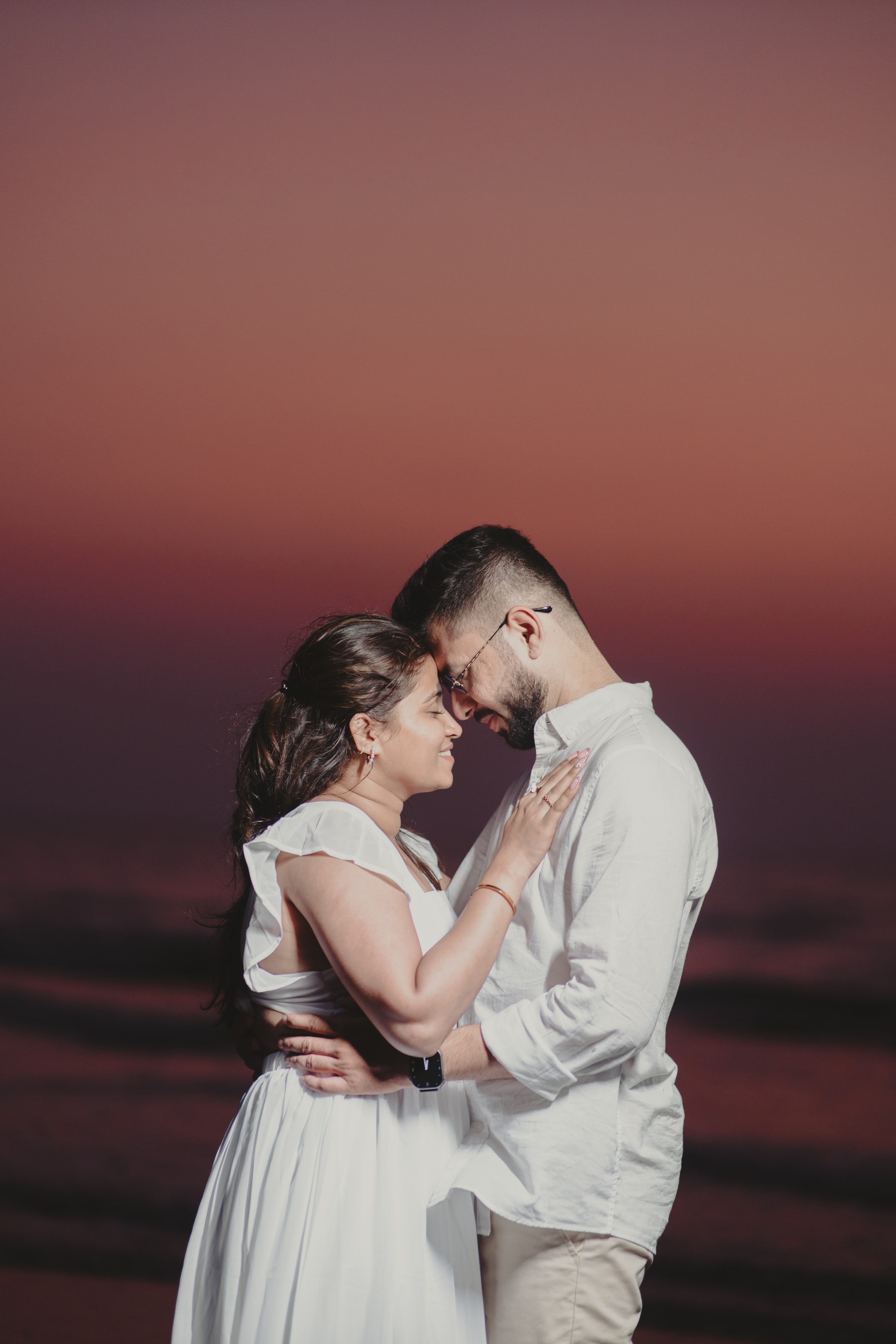 A couple embracing against a red sunset, photograph 02
